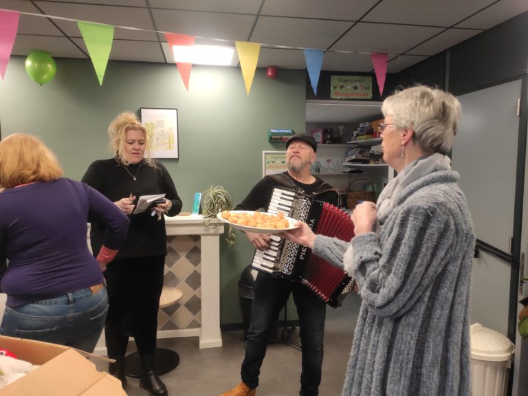 Man met acordeon en zingende mensen